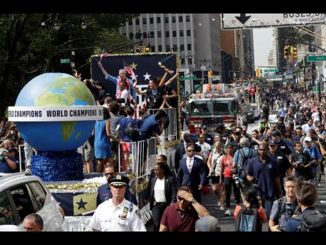 A float with members of the US senior women’s football team and New York Mayor Bill de Blasio (left, back of the trucks) makes its way up Broadway in a ticker-tape parade along the Canyon of Heroes in New York City yesterday. 