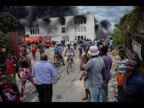 Scores of onlookers stare at the burning building.