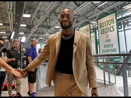 Newly acquired Boston Celtics guard Kemba Walker shakes a hand as he leaves an interview at the Celtics’ basketball practice facility, in Boston, Massachusetts, yesterday.