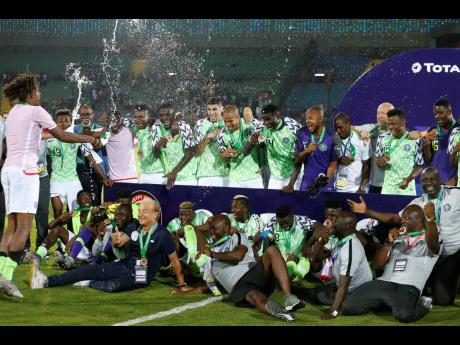 Nigerian players celebrate with bronze medals after the African Cup of Nations third-place match against Tunisia at Al Salam Stadium in Cairo, Egypt, yesterday. (AP Photo/Ariel Schalit)
