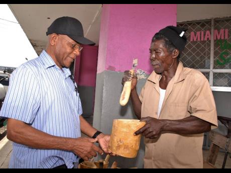 Clement Clunis (left) purchases a mortar and pestle set from Brisette.