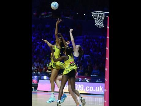 Jamaica’s Shamera Sterling (left) and Jodian Ward (centre) get tangled with Scotland’s Emma Barrie as they go up to collect a pass during their Group G Vitaly Netball World Cup game at the M&S Bank Arena in Liverpool, England, yesterday. Photos courtesy of Collin Reid, Courts Jamaica, Jamaica Tourist Board, Alliance Investments, Dairy Industries, and Supreme Ventures.