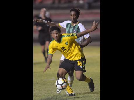 Nicque Daley shields the ball from Dominica defender Jolly Fitz. 