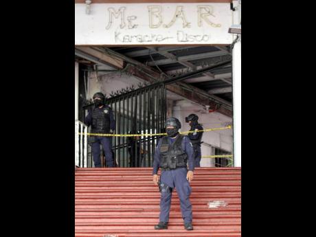 Officers with the State Police of Guerrero and Municipal Police of Acapulco guard an area near a popular bar where gunmen killed and wounded multiple people in Acapulco, Mexico, yesterday. 