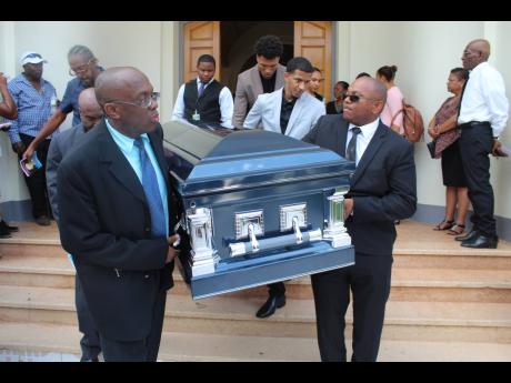 Pallbearers take the casket bearing the body from the William Knibb Baptist Church.