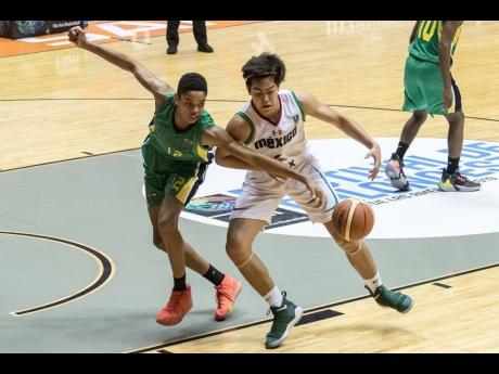 Jamaica’s Flawless Travers (left) challenges Mauricio Reyes of Mexico during their FIBA Under 17 CentroBasket Championships in San Juan, Puerto Rico on yesterday.