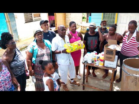 Dave Brown makes a donation to a family in Crowder, Westmoreland, that has had the misfortune of having four of its members struck by blindness.