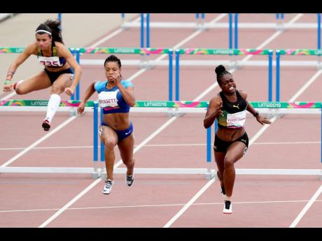 Yanique Thompson of Jamaica makes the final effort to win her semi-final in the women’s 100m hurdles yesterday.