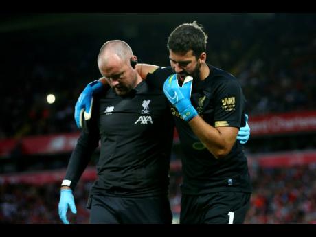 Liverpool goalkeeper Alisson Becker (right) reacts as he leaves the pitch after an injury during the English Premier League match between Liverpool and Norwich City at Anfield in Liverpool last Friday.
