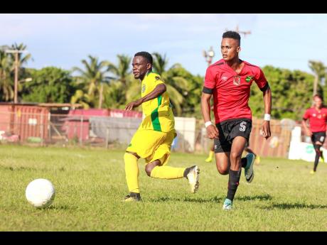 Credit: Lennox Aldred Renoir Elliott (left) of Vere FC challenges Downs FC’s Romario Witter for the ball during their JFF All-Island Confederation Play-Offs encounter at the Wembley Centre of Excellence in Hayes, Clarendon, on Sunday, June 3.