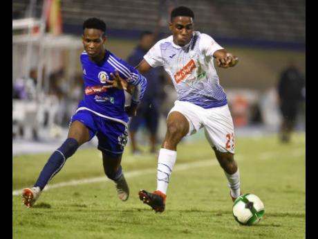 Credit: Gladstone Taylor Cardel Benbow (left) of Mount Pleasant and Emelio Rousseau of Portmore United in a tussle in a Red Stripe Premier League semi-final at the National Stadium in Kingston on April 15, 2019.