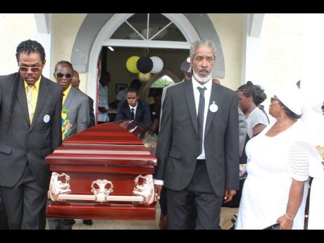 Pall-bearers carry the casket from the church after the thanksgiving service.