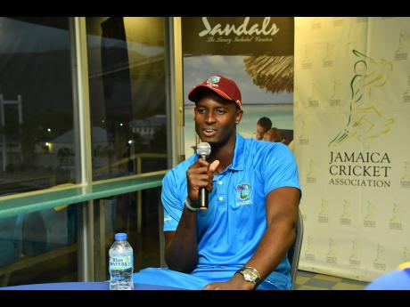 West Indies captain Jason Holder talks with Jamaica U-19 cricketers  at a reception at Sabina Park on Wednesday.