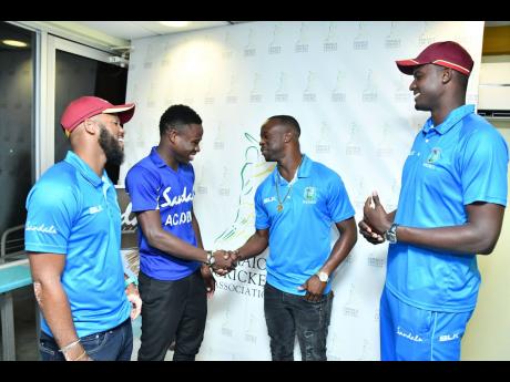 Credit: Contributed West Indies Test players John Campbell (left), Kemar Roach and Jason Holder (right) greet Jamaica Under-19 cricket captain Kirk McKenzie at Sabina Park on Wednesday.