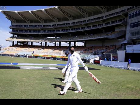 Credit: Ricardo Mazalan Sabina Park’s North Stand is scantily populated as India’s openers KL Rahul (front) and Mayank Agarwal walk to their creases for day one of the second Test match against the Windies last Friday.