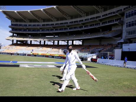 Sabina Park’s North Stand is scantily populated as India’s openers KL Rahul (front) and Mayank Agarwal walk to their creases for day one of the second Test match against the Windies last Friday. 