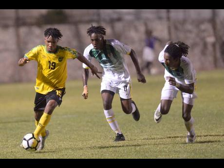 Jamaica’s Tyreek Magee (left) dribbles while under pressure from Dominican defenders George Usher (centre) and Jolly Fitz during their Concacaf U-23 Olympic qualifier at the Anthony Spaulding Sports Complex in Kingston, Jamaica, on Wednesday, July 17. 