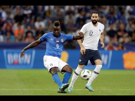 In this 2018 file photo, Italy’s Mario Balotelli (left) kicks the ball while France’s Edil Rami looks on during a friendly match between their countries at the Allianz Riviera stadium in Nice, southern France. 