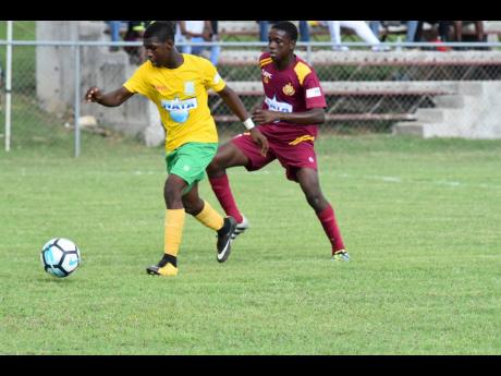 Jay Jamieson (left) of Petersfield High School attempting to dribble away from Port Antonio High School’s Errol Lane in their semi-final encounter of the ISSA/WATA Ben Francis Knockout Cup at the Juici Patties Park on Thursday, November 15, 2018.