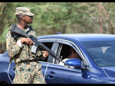 A member of the Jamaica Defence Force mans a state of public emergency checkpoint. 