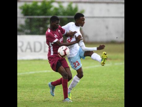 Eltham High School’s Dontae Brown (left) challenges St George’s College player Malique Dawes during their ISSA/Digicel Manning Cup encounter at Winchester Park on Monday. 