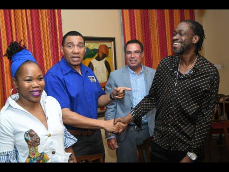 Bounty Killer, the poor people governor, shakes hands with Prime Minister Andrew Holness following a meeting held with entertainers at Vale Royal recently. Looking on is Queen Ifrica (left) and Daryl Vaz.