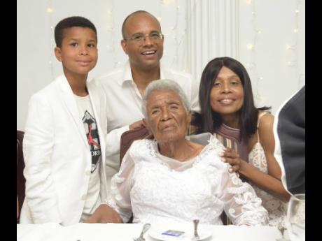 Centenarian Dorothy Austin (seated) celebrates with great-grandson Tristan Jennings (left), grand-daughter Tracy Lake (right) and her spouse, Shawn Jennings, at the Medallion Hall Hotel in Kingston on Saturday.