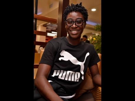 Rushell Clayton ralaxes in Club Kinsgton departure lounge at the Norman Manley International Airport before departing for Doha, Qatar, last Monday.