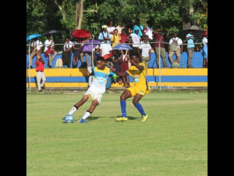 St Elizabeth Technical’s (STETHS) Antonio Biggs (left) comes under pressure from Sydney Pagon’s Tavon Wilke during their ISSA/WATA DaCosta Cup match at the STETHS Sports Complex, yesterday. 