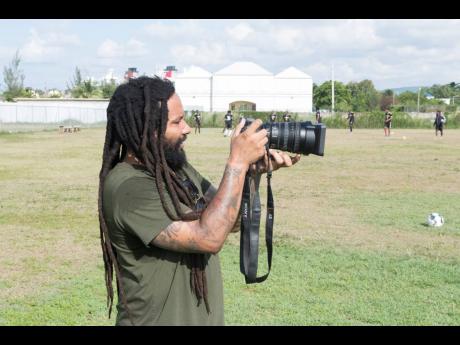 Ky-Mani Marley, owner of Falmouth United Football team, captures images of his team during a training session on Wednesday.