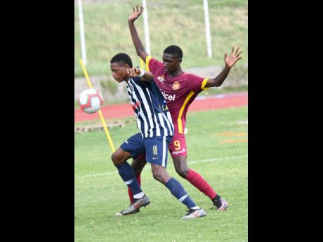 Rushane Thompson (right) of Wolmer’s and Phillon Lawrence of Jamaica College challenge for the ball during the ISSA/Digicel Manning Cup matchup between Wolmer’s and Jamaica College at Stadium East on Monday. 