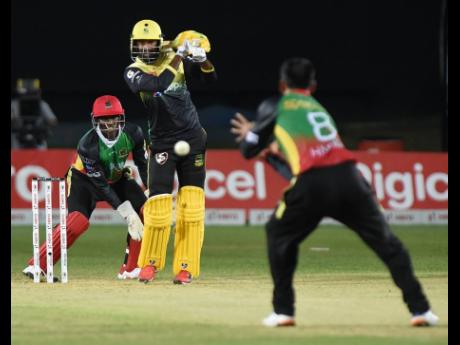 Imran Khan (centre) from the Jamaica Tallawahs is bowled and caught by Mohammed Hafeez (right) from St.Kitts and Nevis Patriots, while the wicketkeeper Devon Thomas (left) looks on.