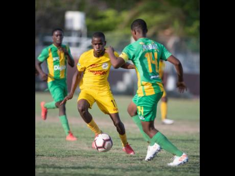 Clive Beckford of Charlie Smith (left) goes on the attack against Vindiesel Isaacs of Kingston High school in their ISSA/Digicel Manning Cup fixture played at Breezy Castle on September 14.