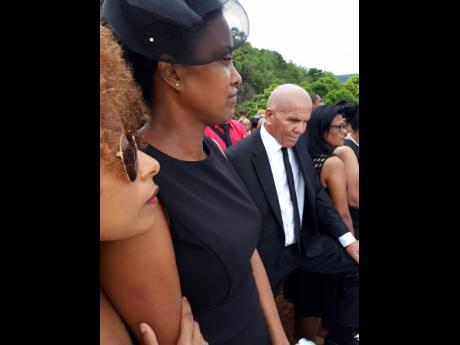 Sadness is evident on the face of Trisha Williams-Singh (centre), granddaughter of the late Eva May Wright, as she stands by the graveside at the funeral last Sunday, in Duff House, Manchester. Offering support is Samara South (left), while her uncle Red Wright looks on.