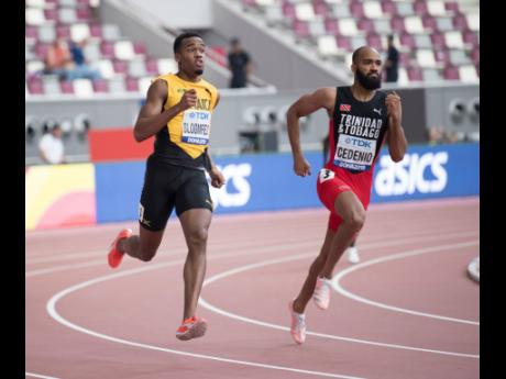 Jamaica’s Akeem Bloomfield (left), negotiates a curve, beside Trinidad and Tobago’s Machel Cedenio, during their Men’s 400m heat at the IAAF World Championships at the Khalifa International Stadium in Doha, Qatar yesterday.