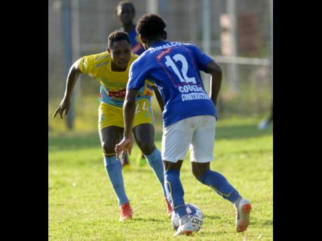 Mark Miller (left) of Waterhouse FC  watches closely as Xahane Reid of Vere United dribbles forward during their Red Stripe Premier League encounter at the Drewsland Stadium on Thursday, September 12.
