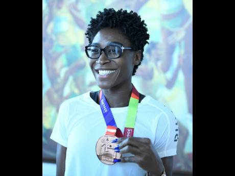 Rushell Clayton displays her bronze medal won  in the women’s 400m hurdles.