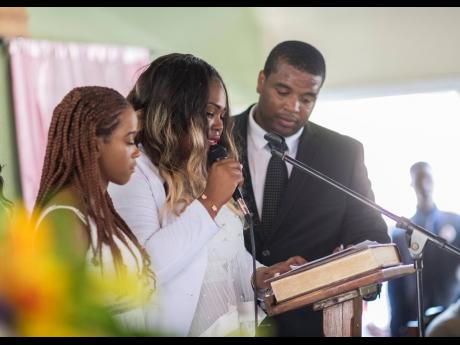  Andre Plummer (right) and Kadine Octable (left) consoles Tameka Pettigrew, who is overcome with grief as she reads a tribute from the cousins to the late Twayne Crooks.