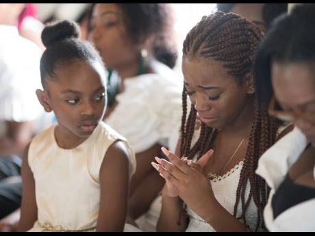 Adrianna Ali looks on as Kadine Octable (right) is overcome with grief as she mourns her cousin Twayne Crooks.