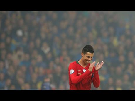 Credit: AP Portugal’s Cristiano Ronaldo applauds during group B qualifying match between Ukraine and Portugal at the Olympiyskiy stadium in Kyiv, Ukraine, yesterday.