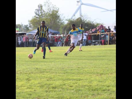 St Elizabeth Technical High School captain Antonio Biggs (right) tracks Munro College’s Torain Young during their ISSA/WATA daCosta Cup game at Munro on September 14. 