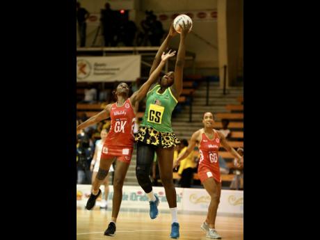 England’s goalkeeper Ama Agbeze (left) tries her best to intercept a pass to Jamaica’s Jhaniele Fowler, while goal defence Layla Guscoth looks on during the third and final Lasco Sunshine Series game between Jamaica and England at the National Indoor Sports Centre on October 15, 2018.