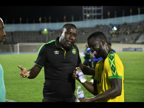 Jamaica’s coach Theodore Whitmore talks with Kemar Lawerence after the Reggae Boyz played The Cayman Islands at the National Stadium on September 9, 2018.