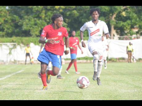 Dunbeholden forward Demario Phillips (left) dribbles as UWI defender Damano Solomon tries to close him down during their Red Stripe Premier League fixture at the Royal Lakes field in St Catherine on October 27.