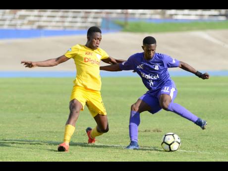 Kingston College’s Renaldo Robinson stylishly cuts away from Charlie Smith High School’s Kareem Griffiths as ‘The Purples’ thrash the Jerome Waite- coached team 5-0 in their Manning Cup quarter-final match yesterday.