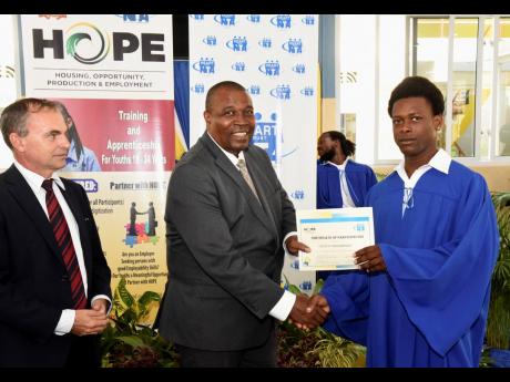 Genus Thompson (right) collecting his certificate from Assistant Commissioner of Police Devon Watkiss. HOPE Programme National Coordinator Martin Rickman looks on.