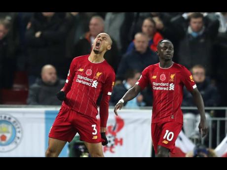 Liverpool’s Fabinho celebrates after scoring his side’s opening goal during their English Premier League match against Manchester City at Anfield Stadium in Liverpool yesterday.