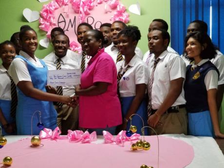 Credit: Romardo Lyons The Aspiring Medical Professionals Society of Ardenne High School presents a cheque for $42,000 to Shullian Brown (centre), public relations officer of the Jamaica Cancer Society.