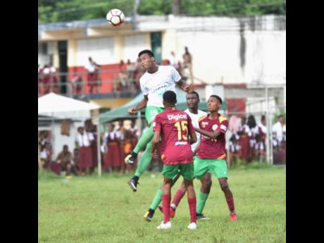 Frome Technical High School’s Clifton Suban clears the ball from ahead of Green Island High School defenders during their ISSA/WATA daCosta Cup match at the Green Island field on Tuesday, October 9, 2018.