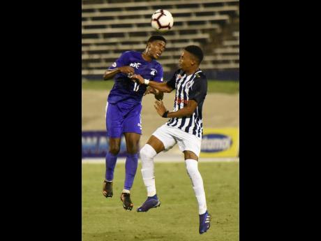 Kingston College’s Sajar Blair (left) beats Jamaica College’s Tyrese Small to a header during their ISSA/Digicel Manning Cup semi-final clash at the National Stadium in St Andrew last night.